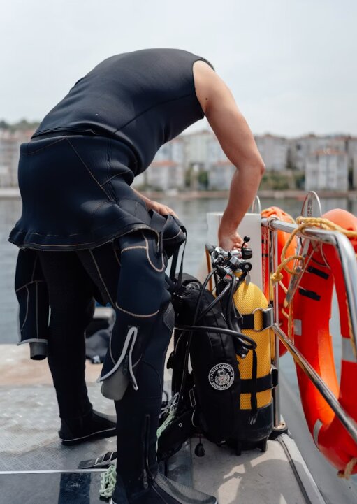 Divers gearing up at the stern platform of a liveaboard before a dive