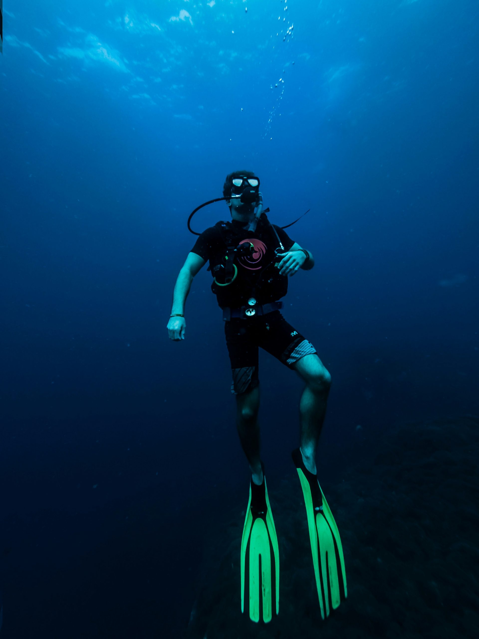 Diver checking a dive computer at depth during a liveaboard dive