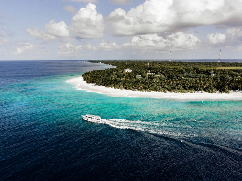 Liveaboard boat anchored in a sheltered tropical bay at sunset