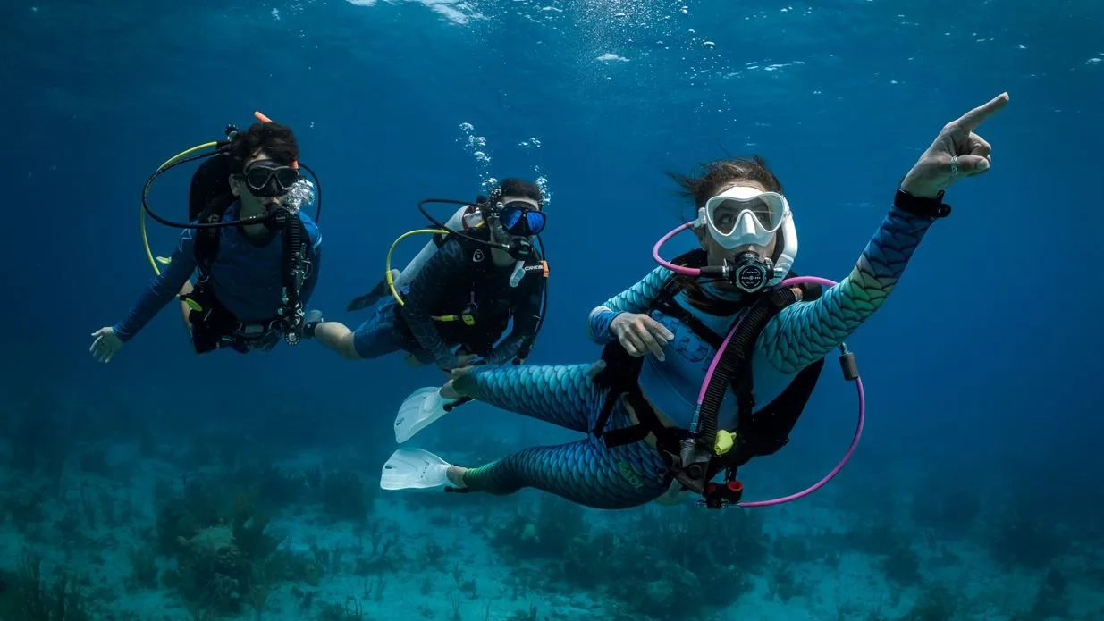 Two Open Water certified divers on a reef at shallow depth during a liveaboard trip