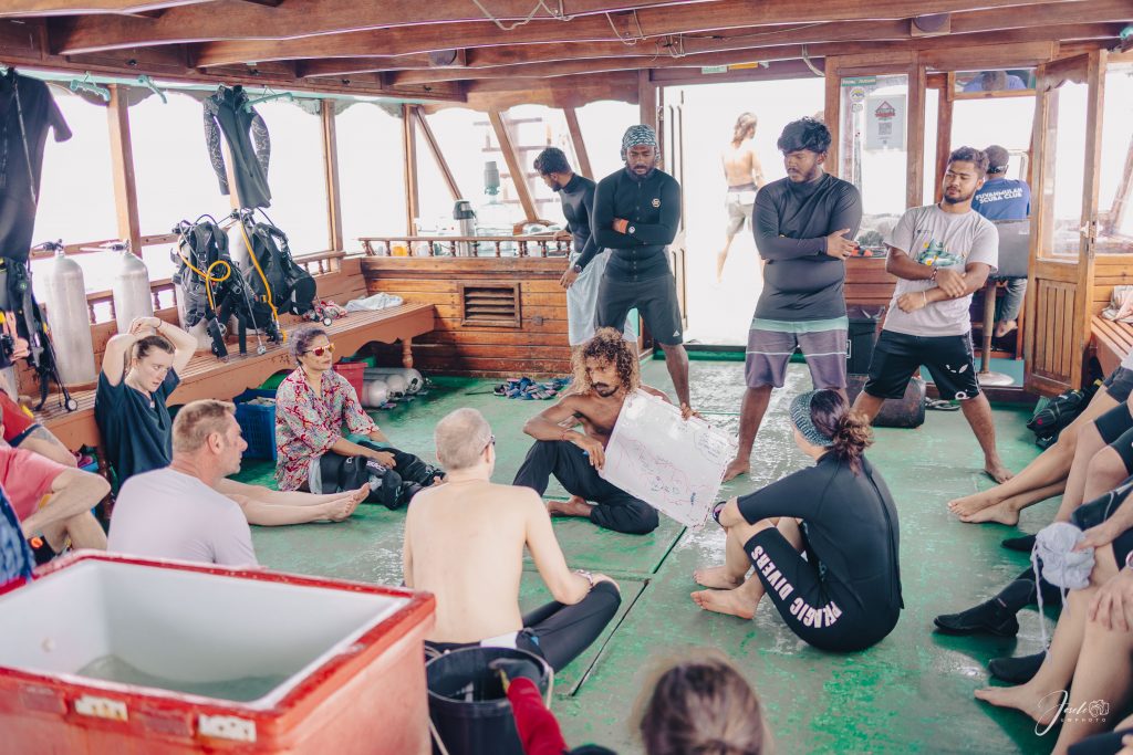 Dive guide briefing divers on deck before a Brothers Islands dive