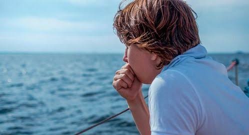 Person looking unwell from motion sickness on a boat