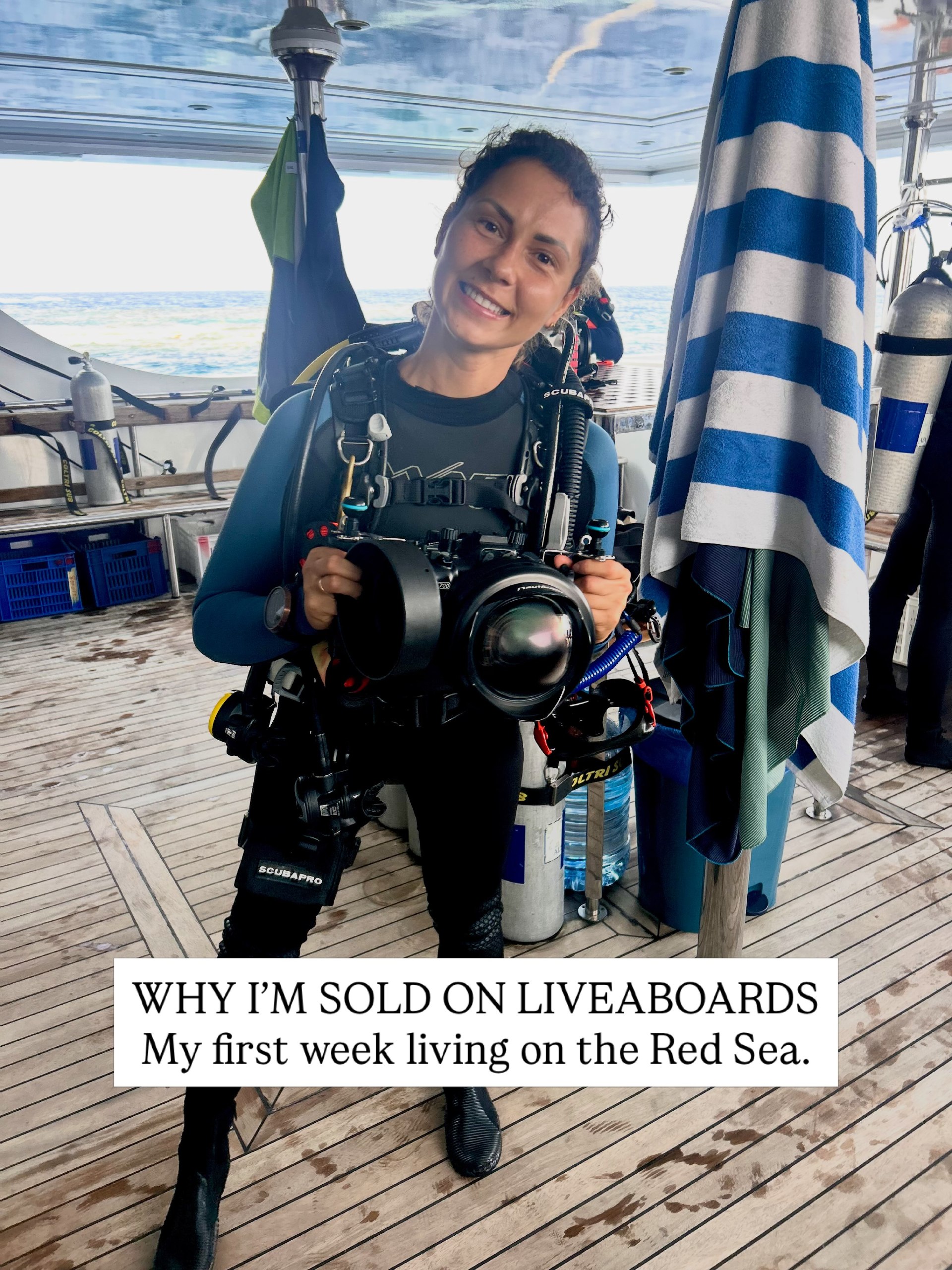 Diver in full equipment holding an underwater camera on the deck of a Red Sea liveaboard