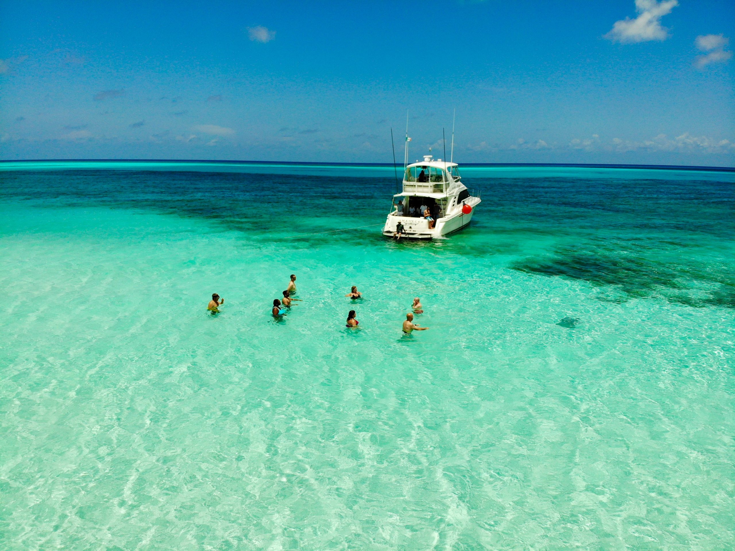 Divers in clear water beside a boat in Cozumel