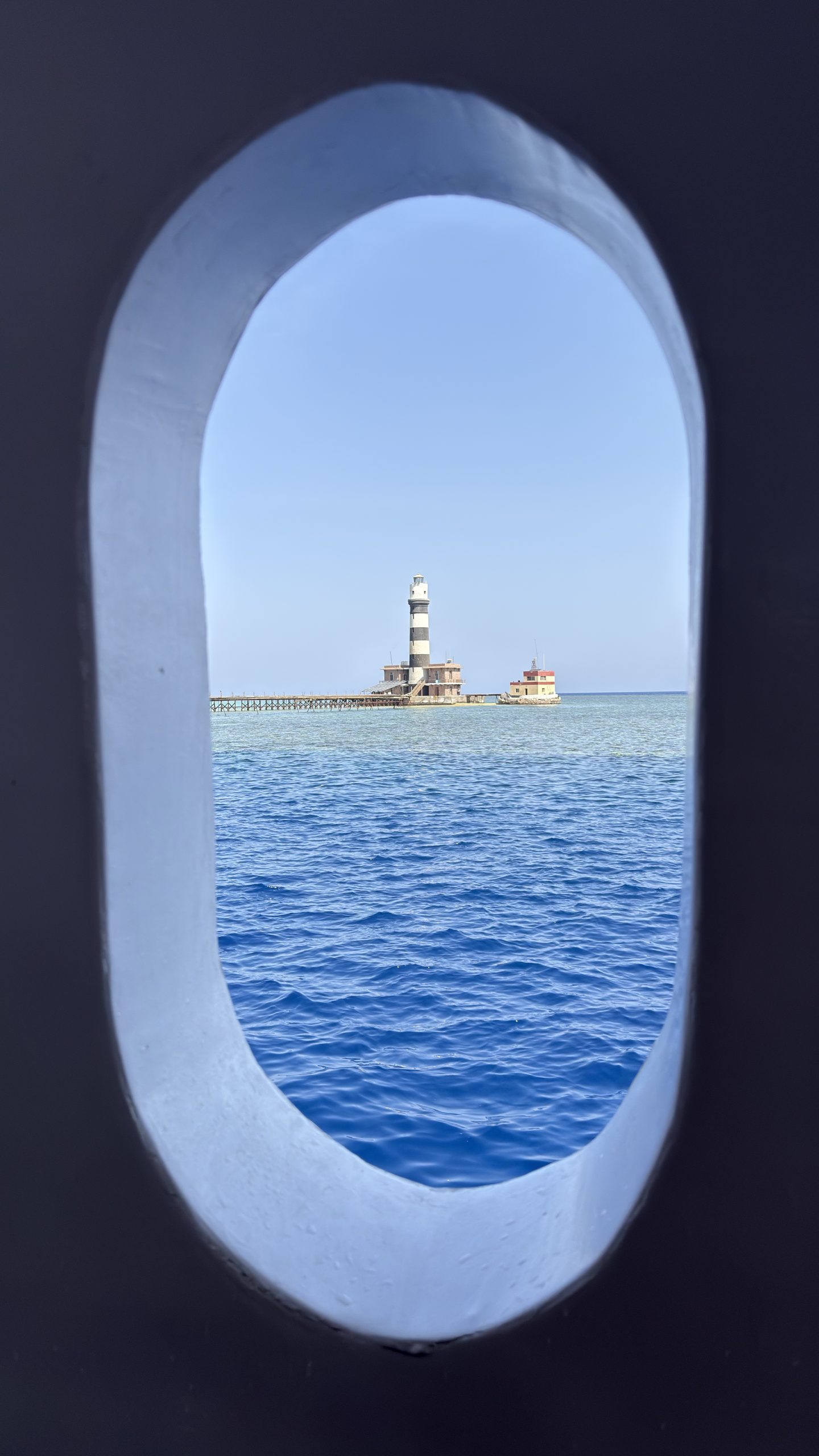 Daedalus Reef lighthouse seen through a liveaboard porthole
