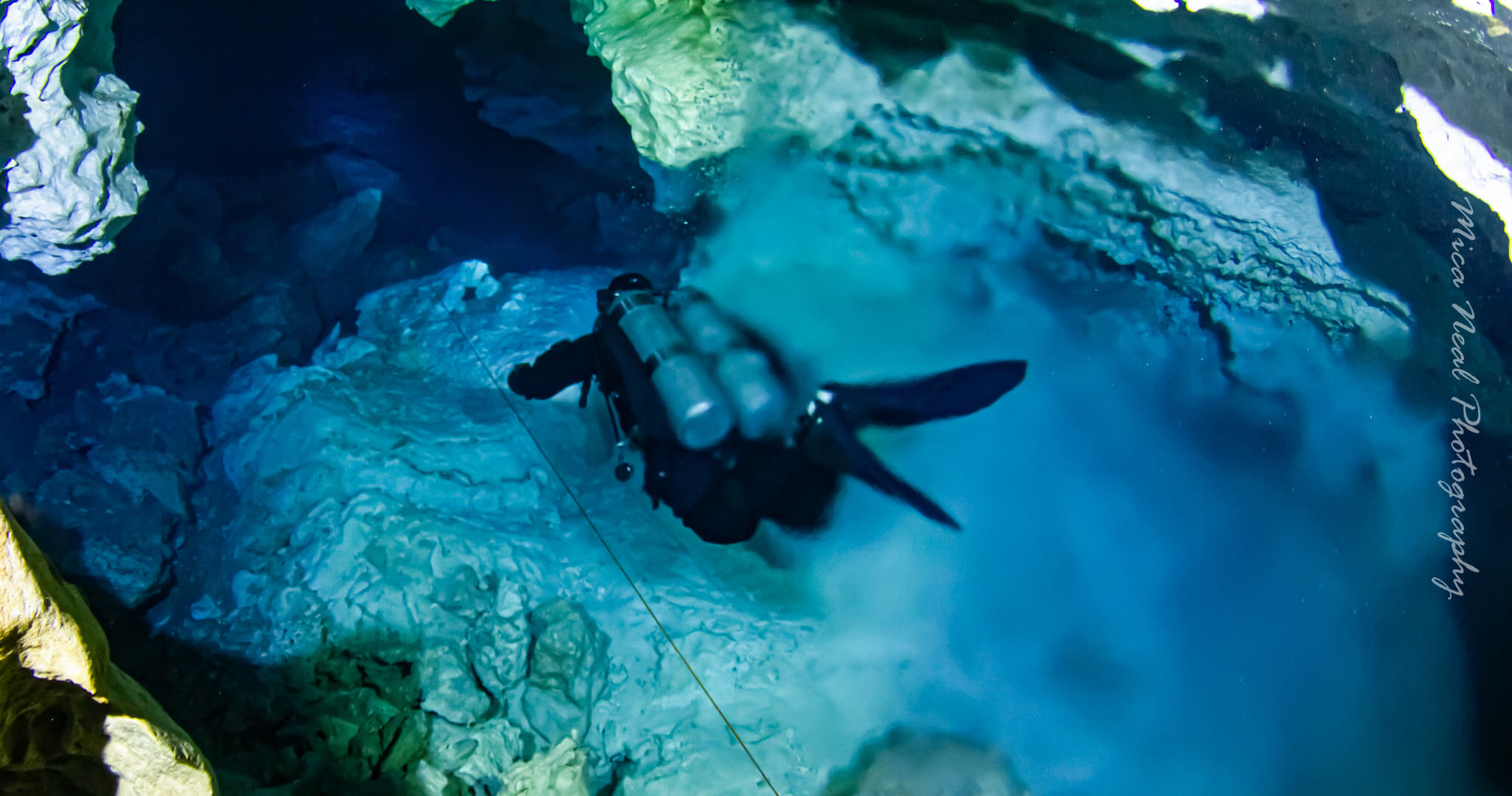 Divers following a guide through a Tulum cenote