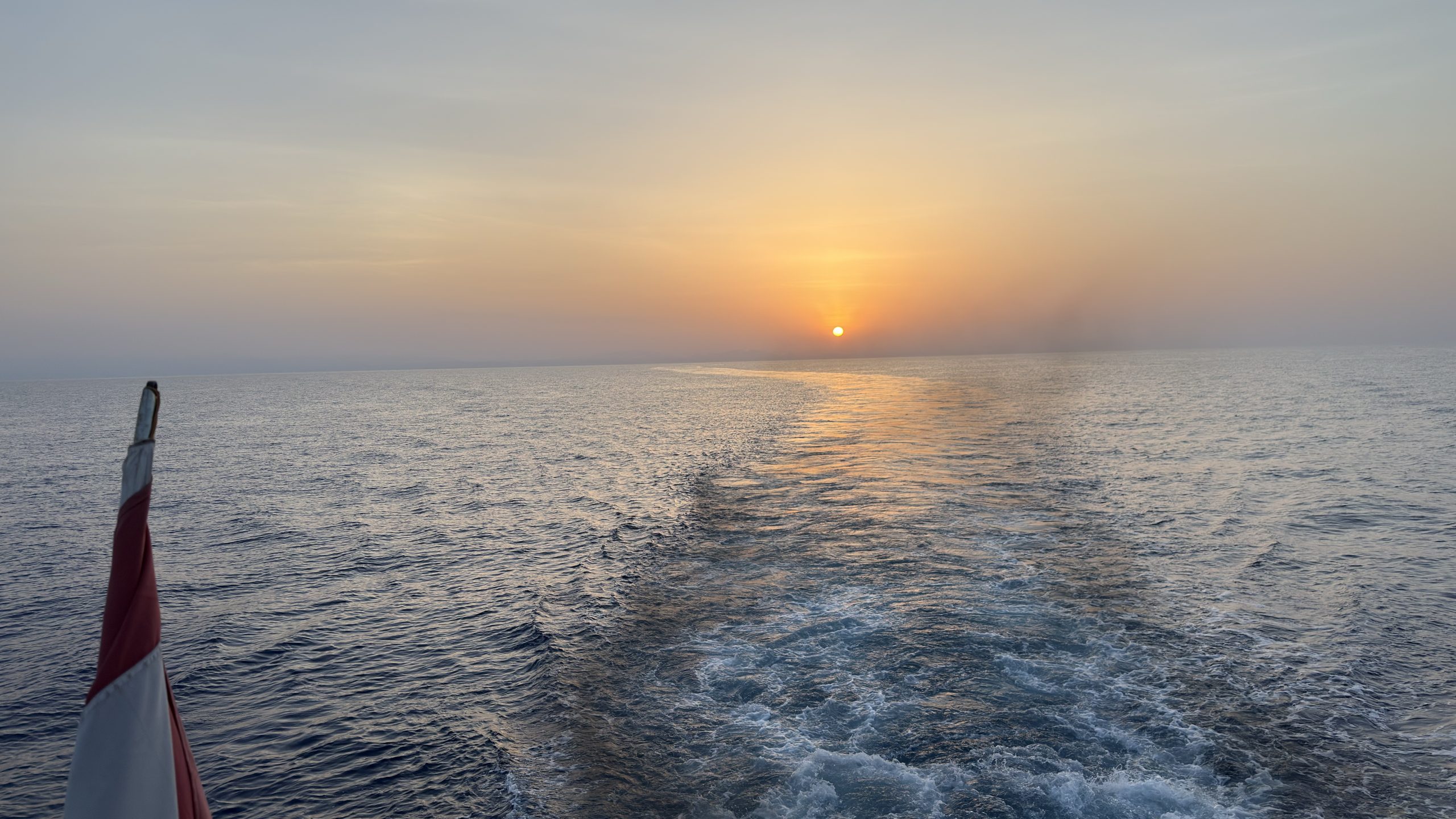 Liveaboard silhouette at sunset with the Egyptian flag, Red Sea