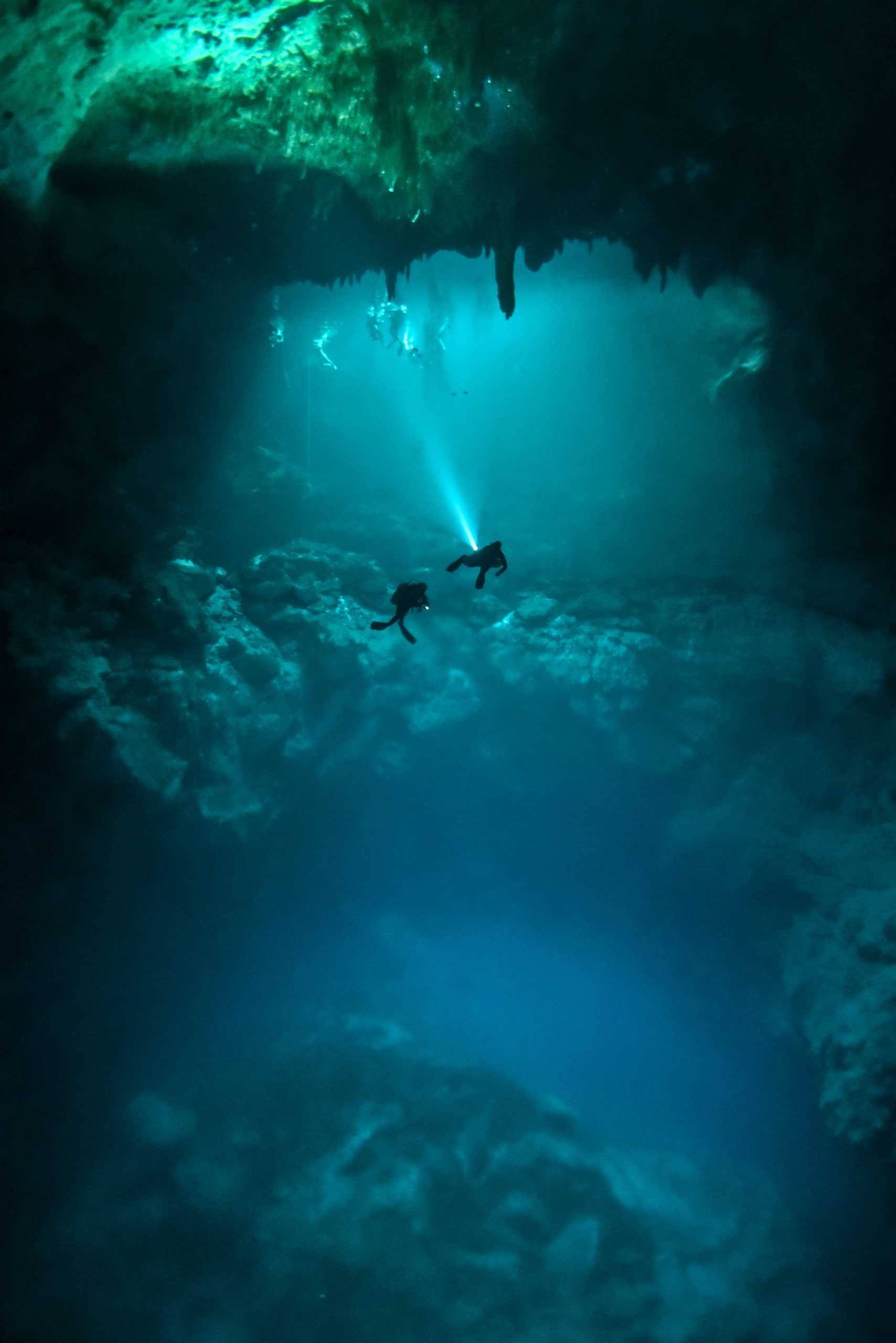 Divers descending into an underwater cave system in Mexico