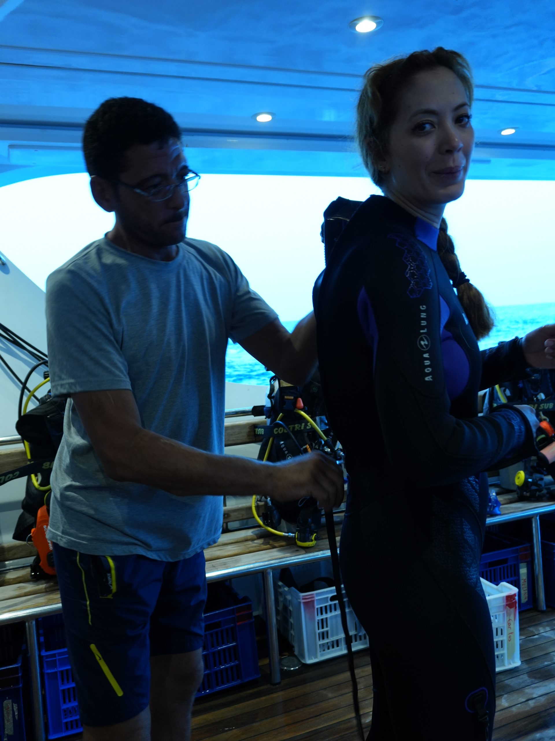 Crew member helping a diver with a BCD on a liveaboard, Egypt