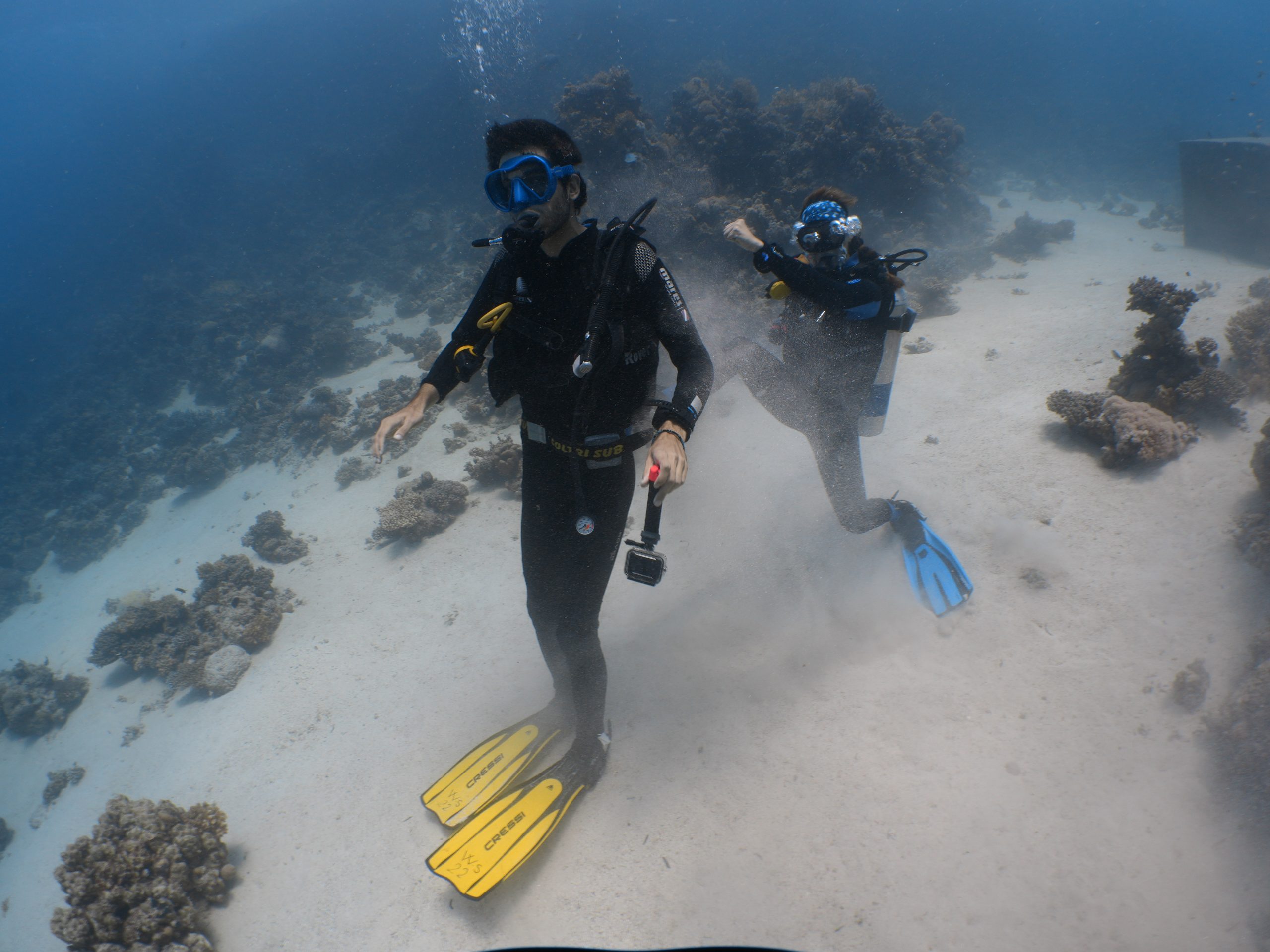 Scuba diver with yellow fins over a sandy reef, Red Sea, Egypt